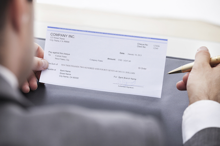 Close-up Of A Businessman Filling Blank Check